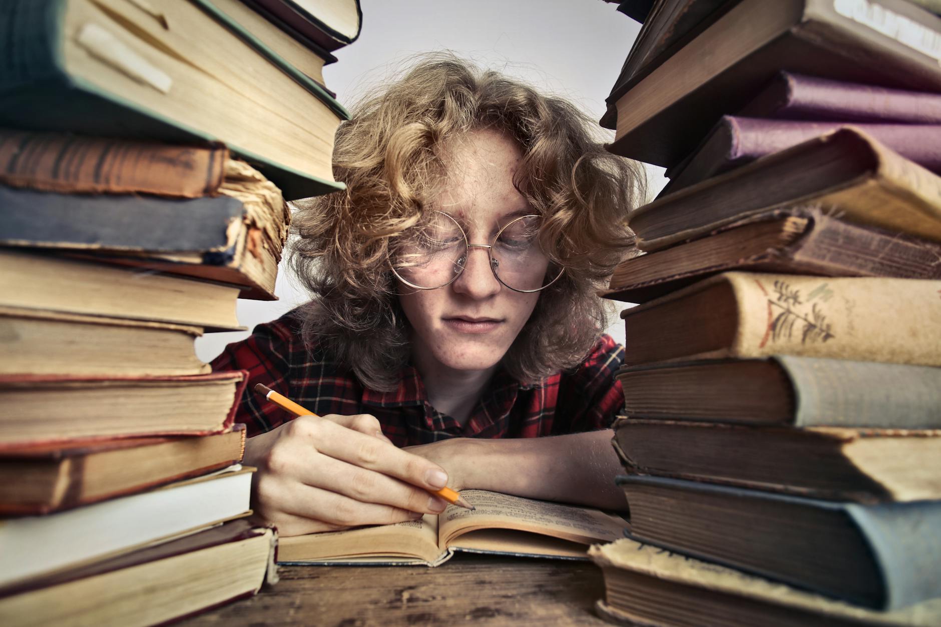 close up photo of person in glasses reading books